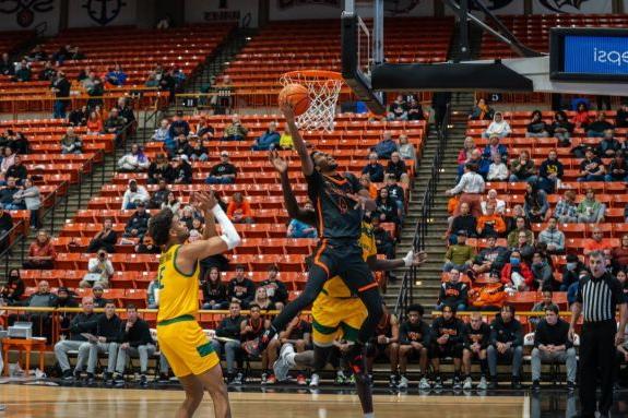 Pacific men's basketball player drives to the basket for a layup