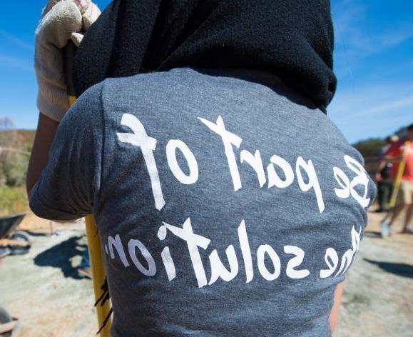 正规博彩十大网站的学生志愿者穿着印有“成为解决方案的一部分”的t恤.